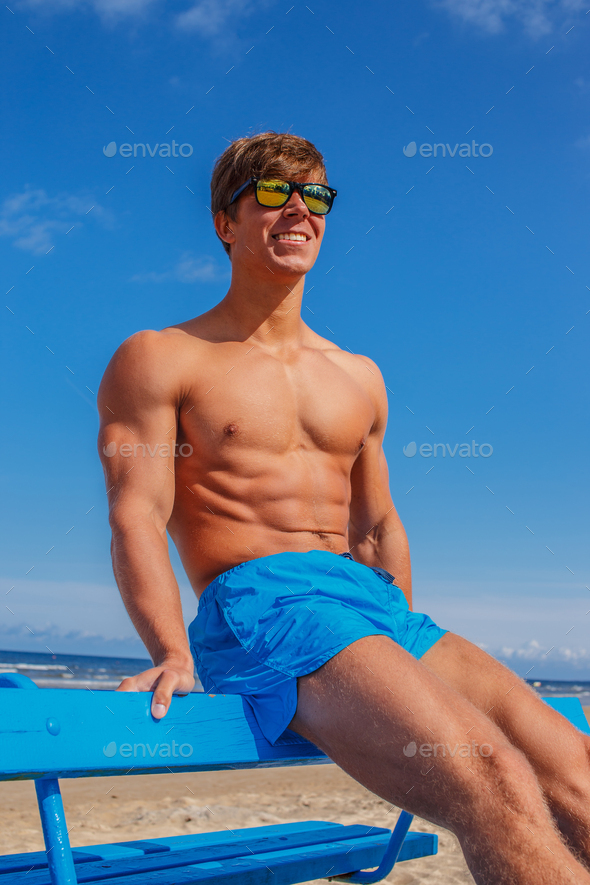 Awesome muscular young guy in blue swim shorts.