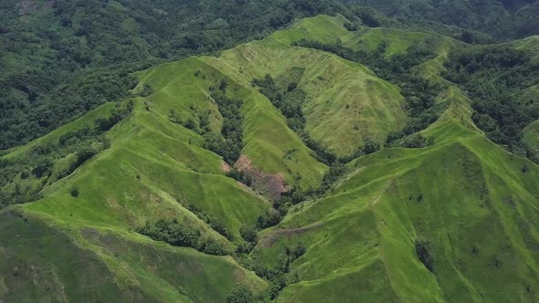 Aerial View. Flight Over a Green Grassy Rocky Hills