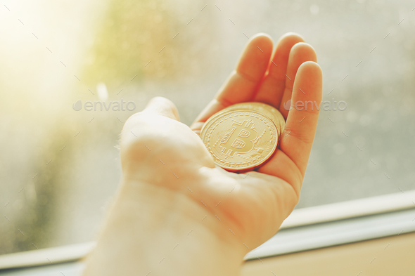 hand holding shiny golden bitcoins, gold money
