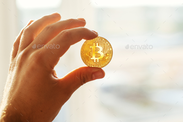 hand holding shiny golden bitcoins, gold money