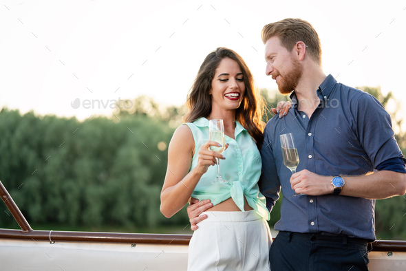 Summer holidays and dating concept. Happy beautiful romantic couple in love hugging with champagne