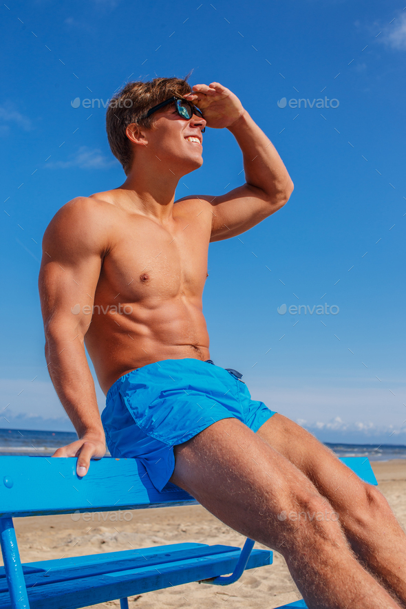Awesome muscular young guy in blue swim shorts.
