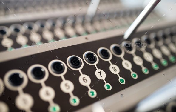 Close-up panel with numbered round buttons and inputs with plugs next to antennas at a secret military base. The concept of an automated military base. Secret military production