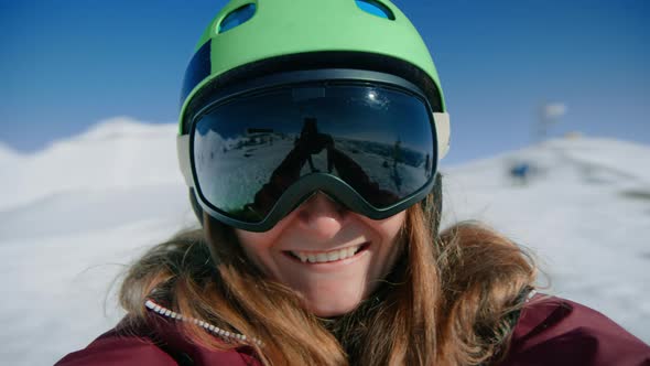 Young Woman Snowboarder Spins in Ski Resort Lift alt