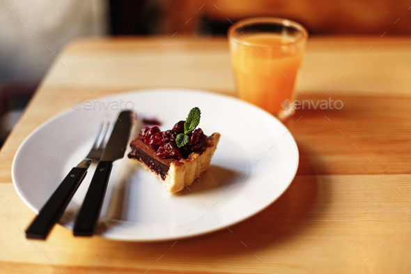 Delicious tasty piece of chocolate tart with cherries and mint