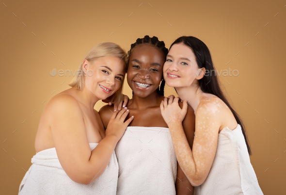 Three multiracial females with different body and skin types wrapped in towel
