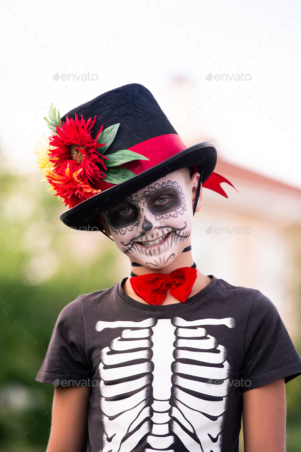 Cute smiling schoolboy with painted face in halloween costume of skeleton - Stock Photo - Images