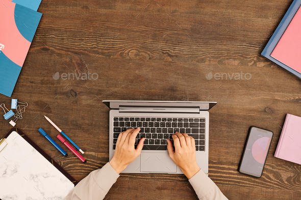 Top view of hands of young contemporary designer or other specialist typing - Stock Photo - Images