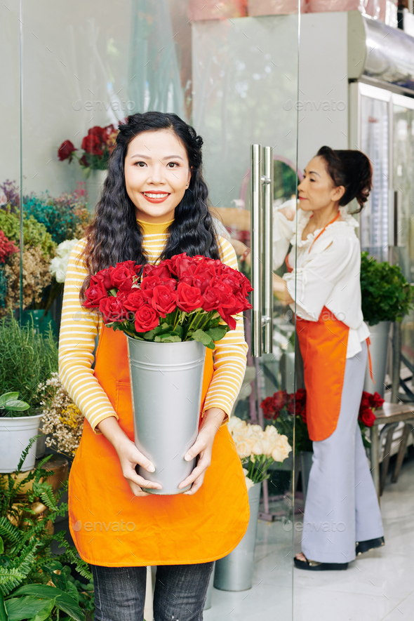 Florist with bucket of red roses