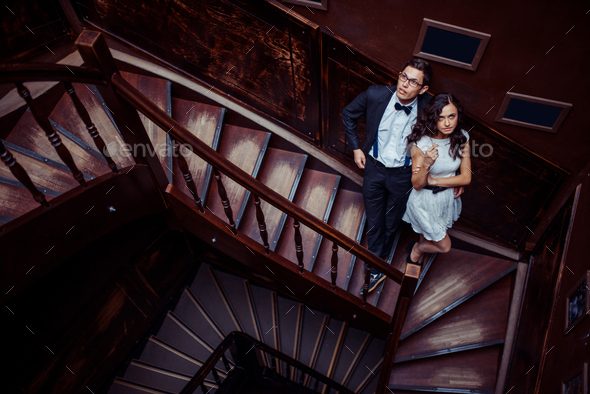 Fashionable young couple standing on stairs and hugging each other.