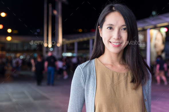 Woman smile to camera in the city at night - Stock Photo - Images