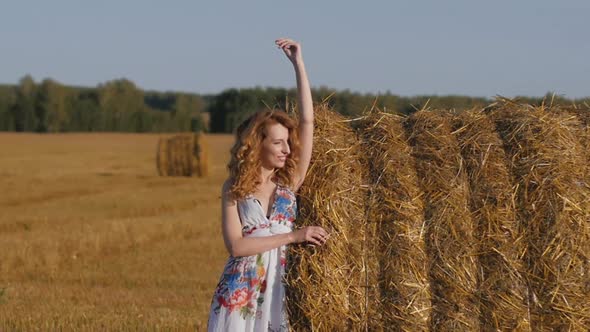 Portrait of Attractive Redhead Woman Dancing Against Background of Fields alt