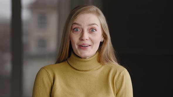 Closeup of Emotional Excited Young Caucasian Woman Blonde with Long Hair Wears Yellow Sweater alt