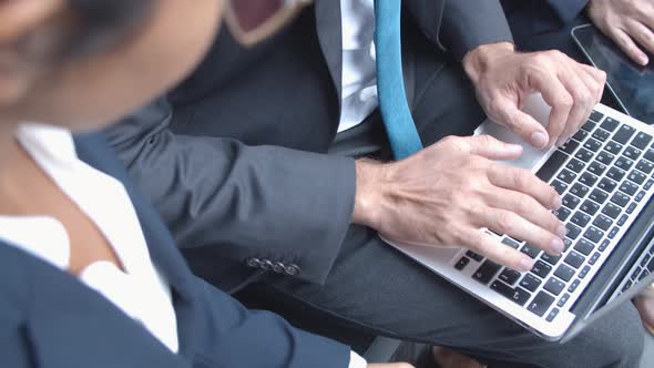 Laptop and Hands of Business Professional Sitting Near Partners alt