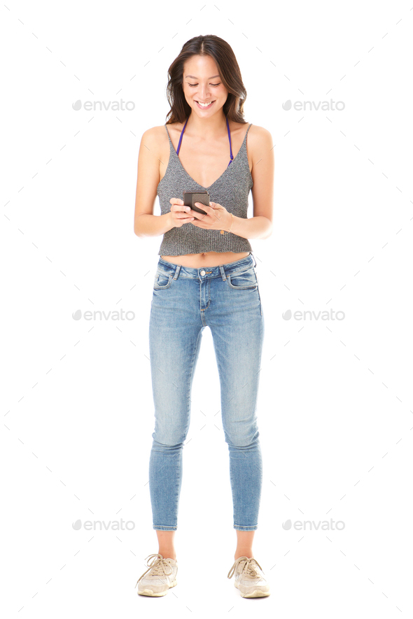 Full body happy young asian woman holding cellphone against