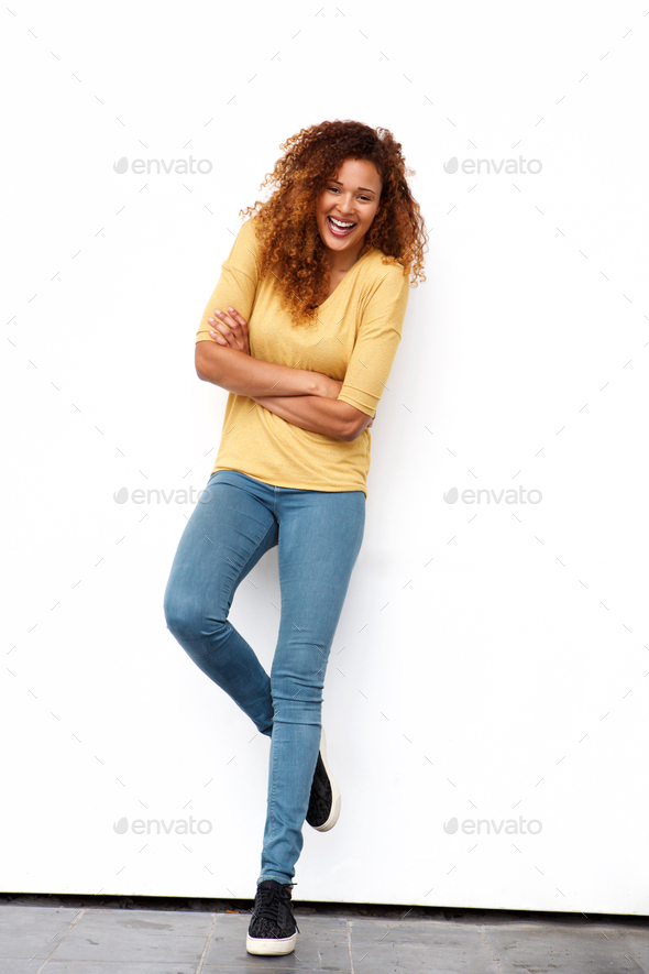 Full body happy young woman with curly hair against white wall