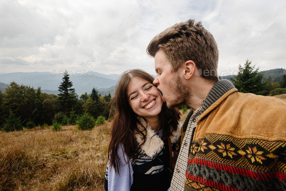 stylish beautiful traveling tender happy couple in the mountains on a background of a forest - Stock Photo - Images
