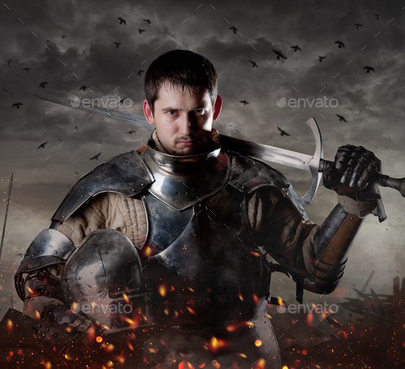 Portrait of a knight with sword on batllefield. Knight with sword in battlefield.