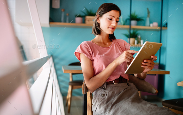 Portrait of cheerful young woman using portable pc for blogging in social networks