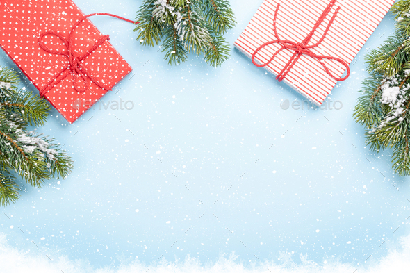 Christmas gift boxes and fir tree over blue background - Stock Photo - Images