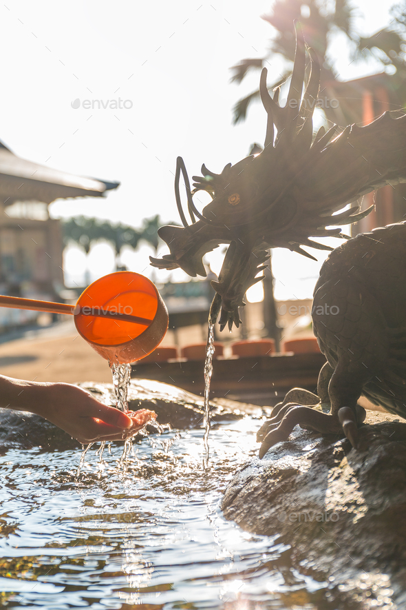 Bamboo water fountain with dragon statue under sunlight