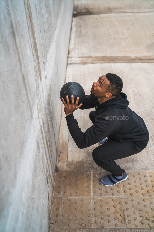Athletic man doing wall ball exercise. - Stock Photo - Images