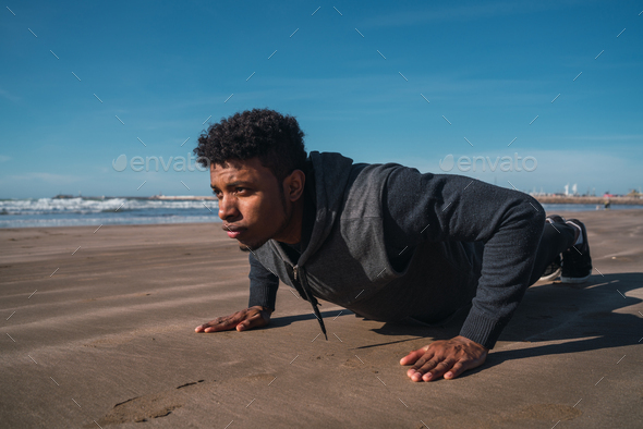Athletic man doing push-ups at the beach. - Stock Photo - Images