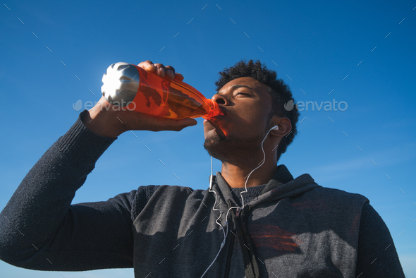 Athletic man drinking something after training. - Stock Photo - Images