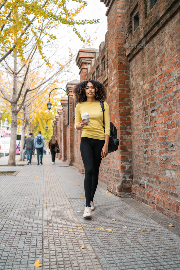Afro-american woman walking on the street. - Stock Photo - Images