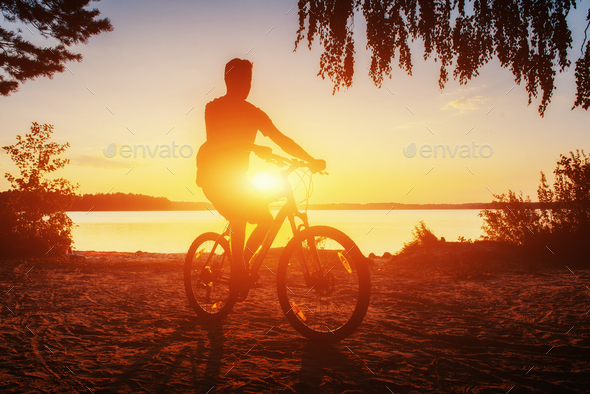 boy on a bicycle at sunset - Stock Photo - Images