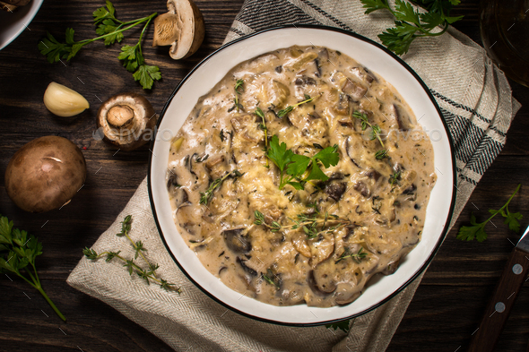 Champignons in cream sauce at white table - Stock Photo - Images
