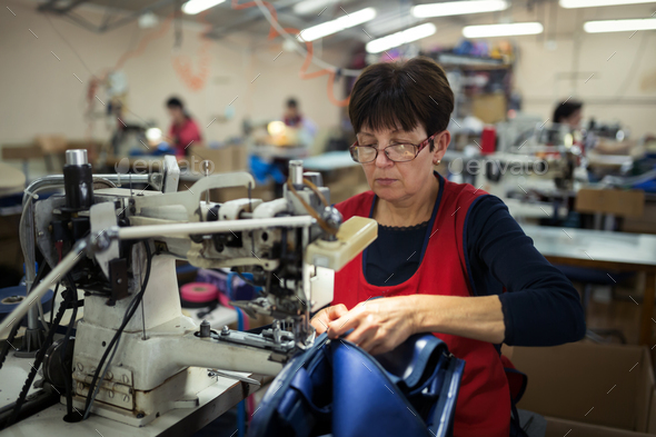 Worker in textile industry sewing - Stock Photo - Images