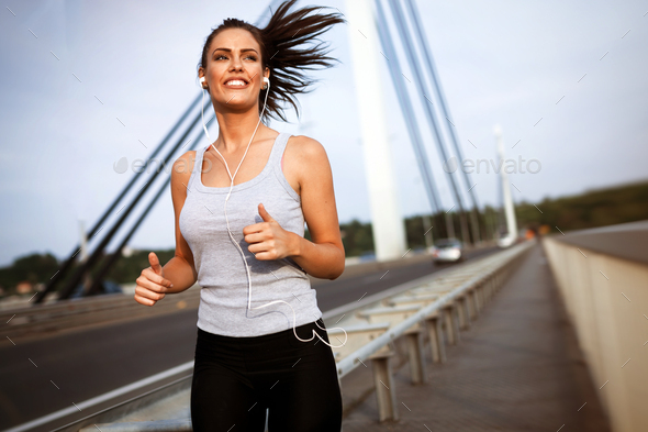Pretty female jogger running outdoors - Stock Photo - Images