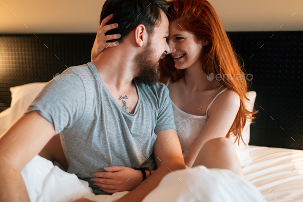 Sensual couple in bed being romantic