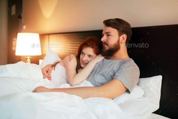 Sensual couple in bed being romantic