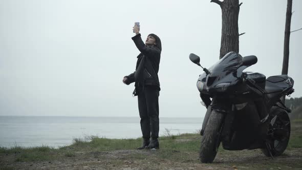 Wide Shot of Embarrassed Caucasian Young Woman Raising Smartphone Searching Mobile Network. Black alt