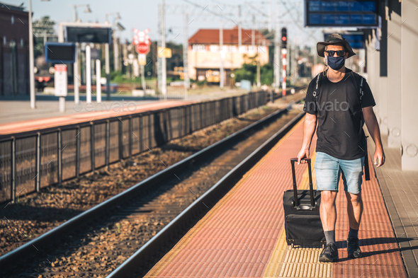 Man with a mask waiting for a train during Covid19 pandemic - Stock Photo - Images