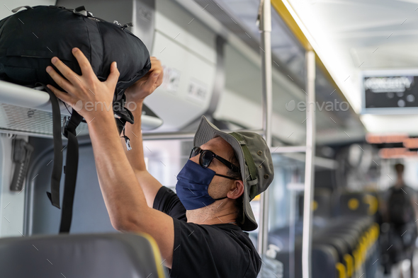 Man with a mask talking traveling in the train during Covid19 pandemic - Stock Photo - Images