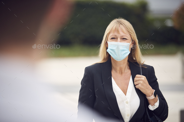Mature Businesswoman Wearing PPE Face Mask Meeting Colleague In Street During Health Pandemic - Stock Photo - Images