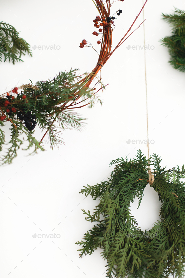 Rustic christmas wreath hanging on white wall, festive decoration. - Stock Photo - Images