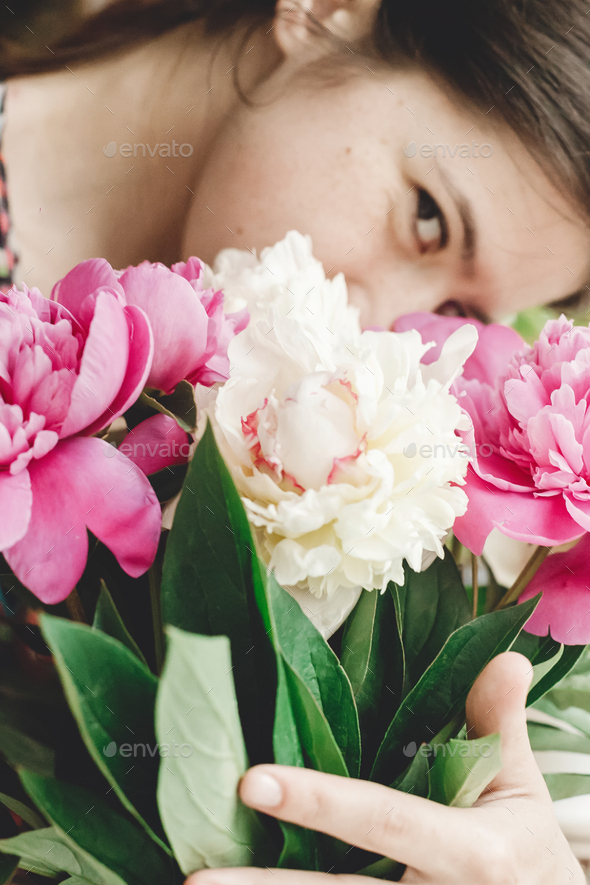 Girl holding and smelling beautiful pink and white peonies bouquet - Stock Photo - Images