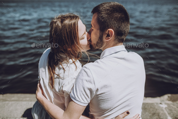 modern woman and man in fashionable white clothes embracing, sensual romantic moment - Stock Photo - Images