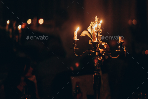 candle light. candles burning on golden candlestick in church at wedding ceremony. atmospheric moment. spirituality concept . hope and sorrow. mourning