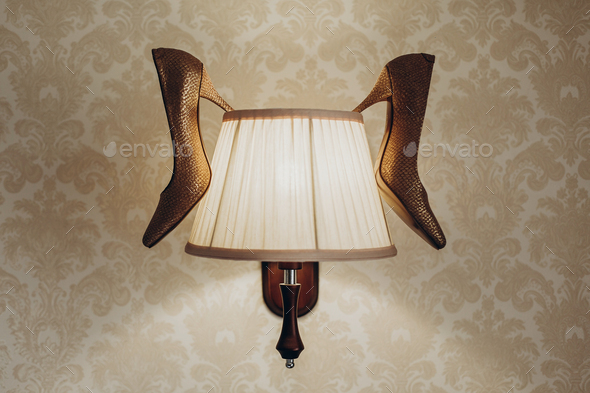 luxury wedding shoes hanging on lamp in hotel room - Stock Photo - Images