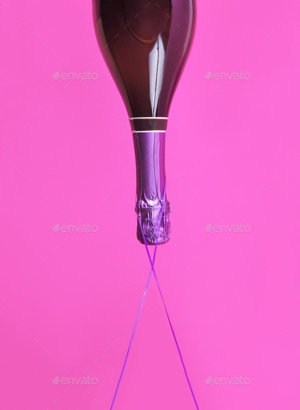 Champagne bottle upside down floats on bold color - Stock Photo - Images