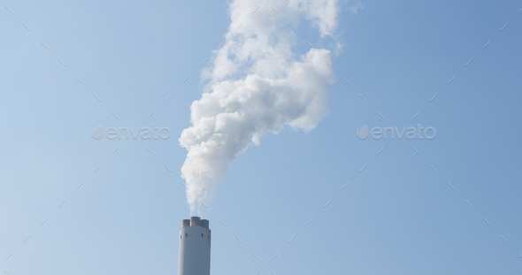 Smoke from factory over blue sky - Stock Photo - Images