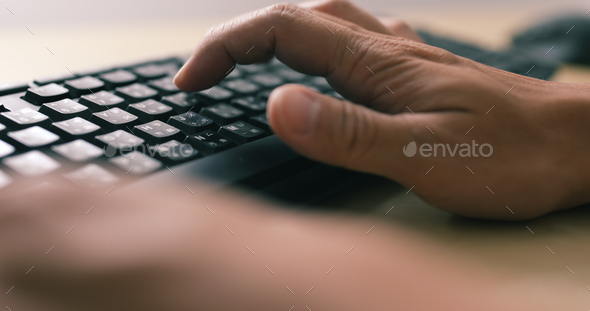 Man hands typing on a computer keyboard - Stock Photo - Images