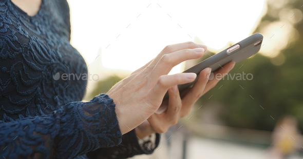 Woman using cellphone with autumn scene - Stock Photo - Images