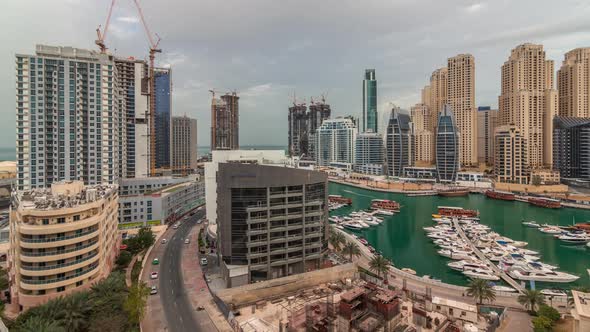 Luxury Yachts Parked on the Pier in Dubai Marina Bay with City Aerial View Timelapse alt