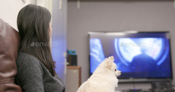Woman watching tv with her dog